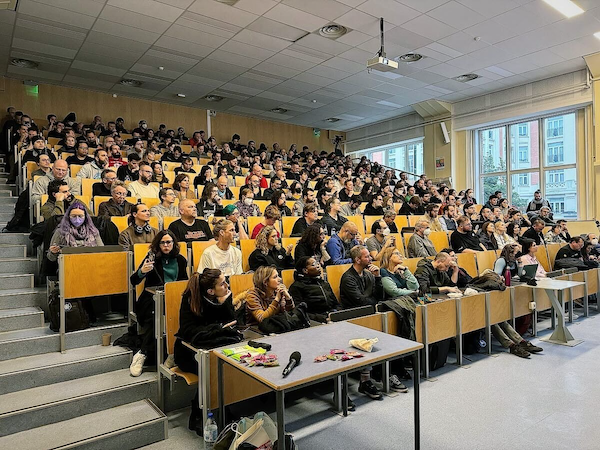 A photo of an auditorium with all seats being fully occupied.