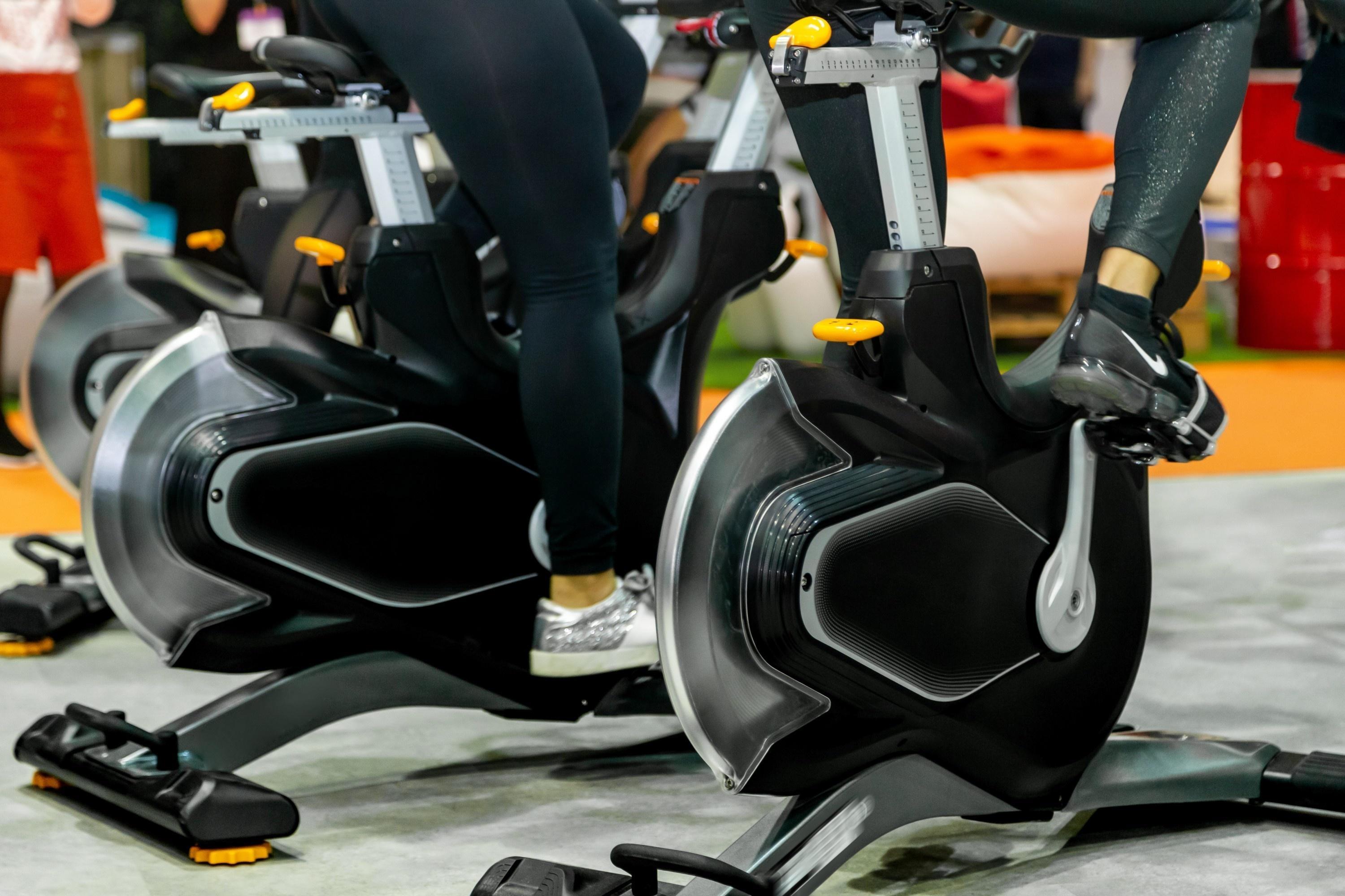 A photo of the handlebars of a spin bike bathed in blue light in a spin studio.