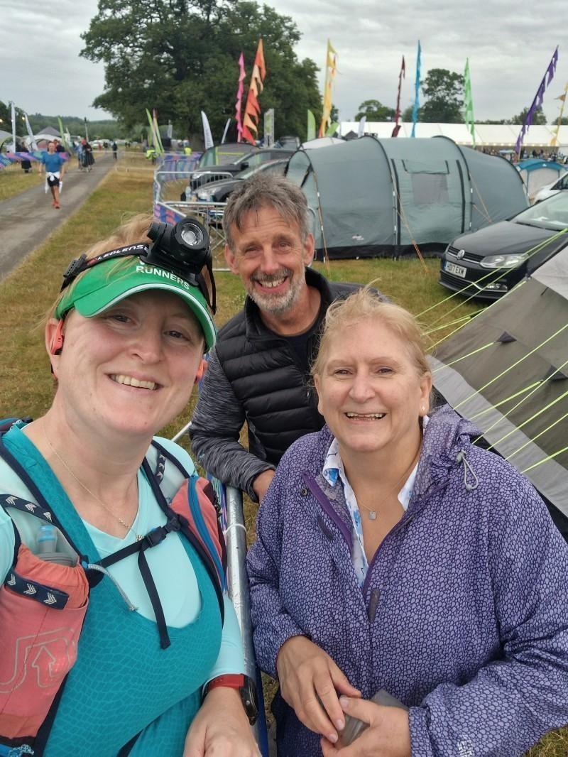 A photo of Ruth, Viryamati and Ruth's mum on the side of the course. Ruth has a headtorch on and her mum is holding her previous lap's empty water bottle.