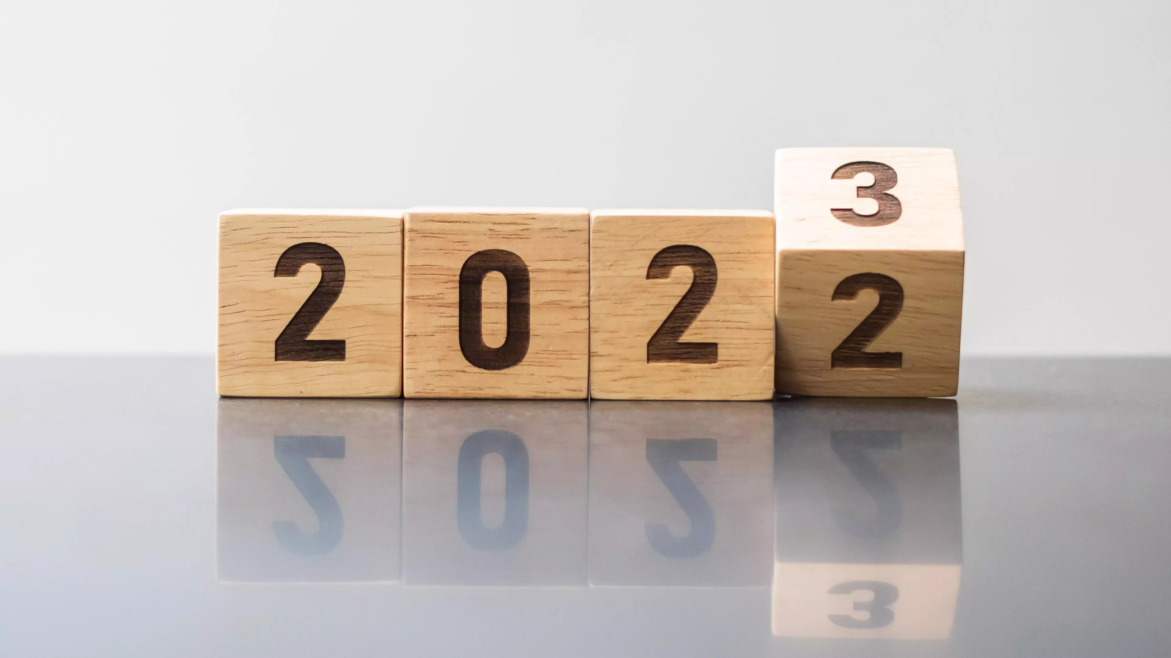 Image of wooden blocks showing 2022 with the last one turning forward to reveal a 3.