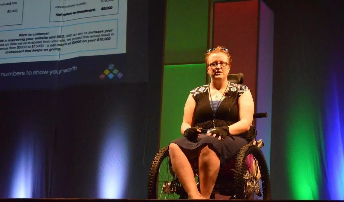 Ruth speaking at the Joomla! World Conference 2014 Cancun, Mexico on stage in her Trekinetic all-terrain wheelchair.